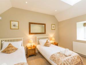 a bedroom with two beds and a mirror on the wall at 3 Bed in Achnacarry CA018 