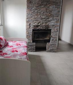 sala de estar con chimenea de piedra y cama en DiVino relax among the vineyards, en Frascati