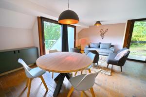 sala de estar con mesa de madera y sillas en Nenuphar en Vielsalm