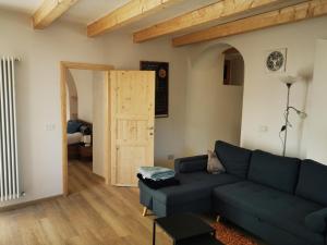 sala de estar con sofá azul y puerta abierta en Appartamento sci & laghi "Tre Fontane", en Tione di Trento