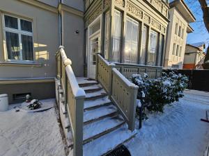 a house with snow on the stairs in front of it at Sopot Special Apartments in Sopot