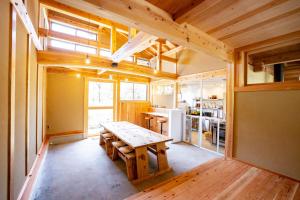 una cocina con una mesa de madera en una casa en Ecommodation 百のやど en Aone