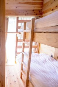 1 Schlafzimmer mit 2 Etagenbetten in einer Hütte in der Unterkunft Ecommodation 百のやど in Aone