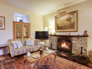 a living room with a couch and a fireplace at 6 Bed in Kinlocheil CA139 in Fassfern