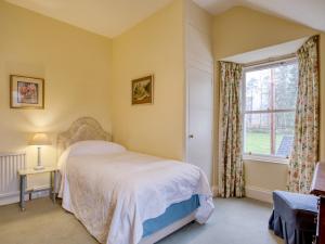 a bedroom with a bed and a window at 6 Bed in Kinlocheil CA139 in Fassfern