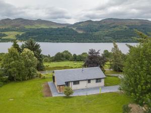 an aerial view of a house with a lake at 3 Bed in Pitlochry CA207 in Struan