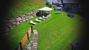 a group of benches sitting on a lawn with a tent at Hotel Nordik in Santa Caterina Valfurva