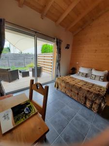 ein Schlafzimmer mit einem Bett und einem großen Fenster in der Unterkunft Au Cœur des Lacs - Chambres d'hôtes in Gérardmer