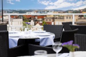 a table with white plates and wine glasses on a balcony at Pytloun Boutique Hotel Prague in Prague