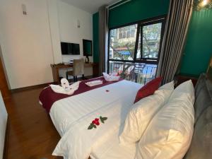 una camera da letto con un grande letto bianco con fiori sopra di NT Elysian hotel a Hanoi