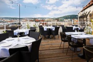 restauracja ze stołami i krzesłami na balkonie w obiekcie Pytloun Boutique Hotel Prague w Pradze