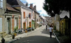 Una mujer caminando por una calle en un pueblo en Le Manivert, en Vitry-Laché