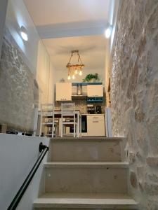 a staircase leading to a kitchen with a stone wall at Geometric Donna Giulia in Casamassima