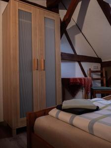 a bedroom with a bed and wooden cabinets at Ferienhof Bahlens-Schur in Friedland
