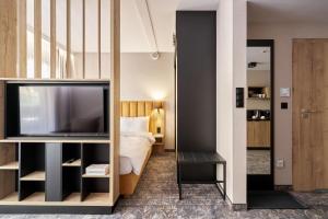 Pokój hotelowy z telewizorem i łóżkiem w obiekcie Złoty Horyzont Resort Szklarska Poręba w Szklarskiej Porębie