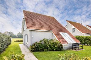 a white house with a red roof at Summio Zeeland Village in Scharendijke