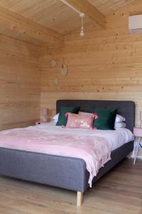 a large bed in a room with wooden walls at Bijou Bunker in Whitstable