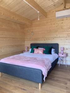 um quarto com uma cama grande num quarto de madeira em Bijou Bunker em Whitstable