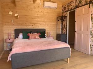 a bedroom with a bed and a wooden wall at Bijou Bunker in Whitstable