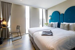 1 dormitorio con 1 cama grande y cabecero azul en Benjarong Hotel Bangkok, en Ban Zong Katiam