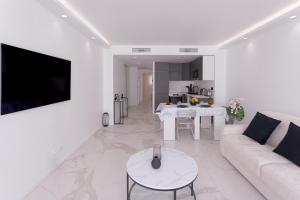 a white living room with a couch and a table at L'unique Maubourg - Next Hotel Martinez - Terrasse in Cannes