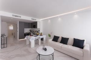 a white living room with a couch and a table at L'unique Maubourg - Next Hotel Martinez - Terrasse in Cannes