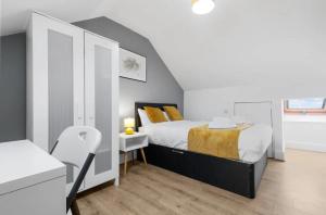 Dormitorio con cama y mesa pequeña con lámpara en Cosy 3 Bedrooms House with a Driveway close to Coventry Town Centre and University, en Coventry