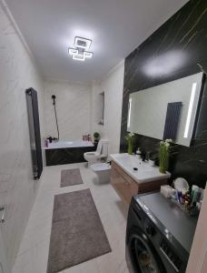 y baño con bañera, aseo y lavamanos. en Daric Residence Apartaments, en Fălticeni