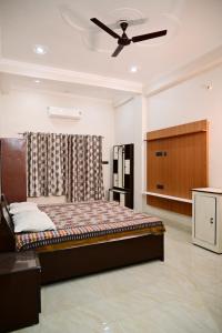 a bedroom with a bed and a ceiling fan at Surendra Villa in Ayodhya