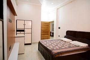 a bedroom with a bed and a kitchen in it at Surendra Villa in Ayodhya