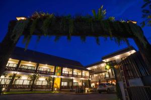 vistas a la parte delantera de un hotel por la noche en BOSS HOTEL CHIANGMAl en Chiang Mai
