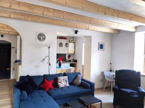 un soggiorno con divano blu e 2 sedie di Appartamento sci & laghi "Tre Fontane" a Tione di Trento