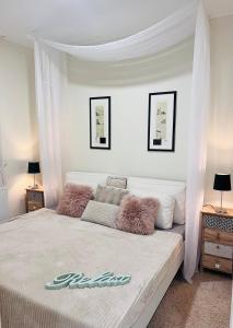 um quarto com uma grande cama branca e um dossel em Villa Relax Apartman em Gárdony