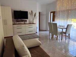 ein Wohnzimmer mit einem Sofa und einem Tisch mit Stühlen in der Unterkunft Villa Relax Apartman in Gárdony