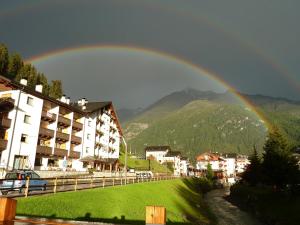Un arcobaleno nel cielo sopra una città di Hotel Nordik a Santa Caterina Valfurva
