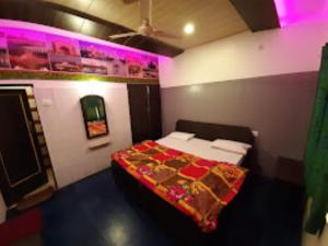 um quarto com uma cama num quarto com luzes roxas em HOTEL TAJ DELUXE, Agra em Agra