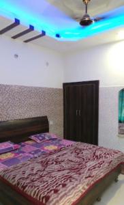 Ce lit se trouve dans une chambre aux tons bleus. dans l'établissement HOTEL TAJ DELUXE, Agra, à Agra
