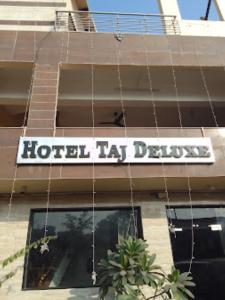 um sinal de hotel la delay na frente de um edifício em HOTEL TAJ DELUXE, Agra em Agra