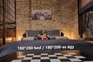 a bedroom with a bed and a brick wall at URBAN in Old Town (Kecskemét) in Kecskemét