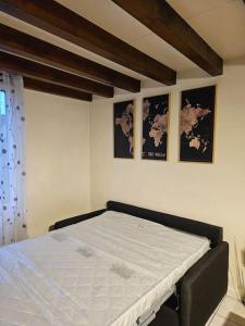 a bedroom with a bed and two pictures on the wall at Triplex Proche Charles De Gaulle in Vaujours