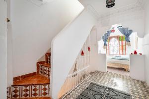 丹吉爾的住宿－Maison Ghazal，白色的房间,设有楼梯和一张床