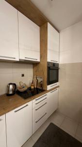 a kitchen with white cabinets and a microwave at cream apartment in Banja Luka