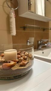 - une bougie dans un bol sur un comptoir dans la salle de bains dans l'établissement cream apartment, à Banja Luka