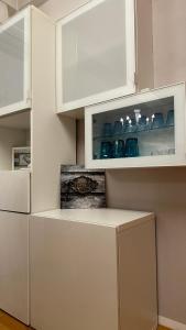 a kitchen with white cabinets with blue dishes in it at cream apartment in Banja Luka