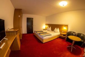a hotel room with a bed and a table and chairs at Apparthotel Alte Innbrücke-24Std-Self-Check In in Neuhaus am Inn