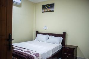 - une chambre avec un lit doté de draps et d'oreillers blancs dans l'établissement Fully Furnished 1- Bedroom in East Legon, à Madina