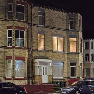 un bâtiment en briques avec des voitures garées devant lui dans l'établissement Redcar Seaview Apartments, à Redcar