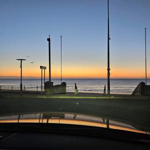 een uitzicht op de oceaan bij zonsondergang vanuit een auto bij Redcar Seaview Apartments in Redcar