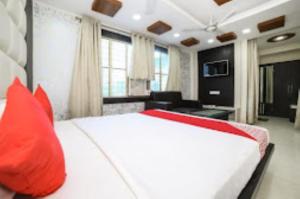 1 dormitorio con 1 cama blanca grande con almohadas rojas en HOTEL VEER BHUMI PALACE Jhansi, en v