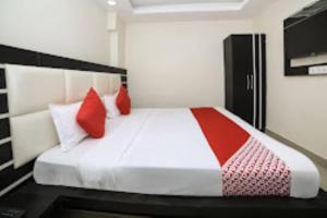 1 dormitorio con 1 cama grande con almohadas rojas en HOTEL VEER BHUMI PALACE Jhansi, en v